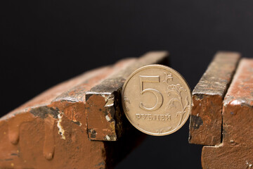 A 5-ruble coin in a metal vise. Concept of economic problems. Selective focus. Close up.