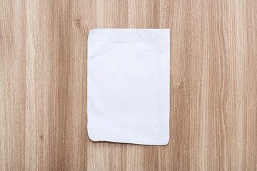 White blank sheet of paper on a wooden table.