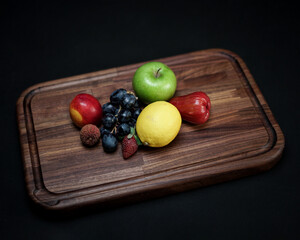 photo of wooden cutting board products and wooden trays, by adding properties to a variety of fresh fruit. Looks very attractive and elegant.