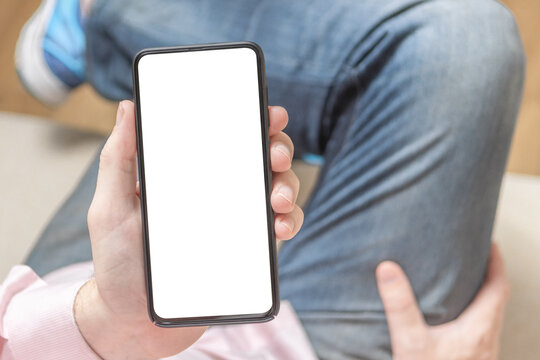 Mockup image of man's hands holding white mobile phone with blank screen. Woman's Hand Holding Cell Phone With Blank Screen. Mockup phone.
