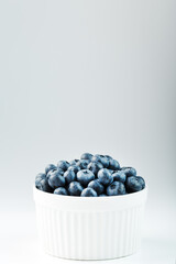Blueberries are ripe berries in a white Cup on a white background.