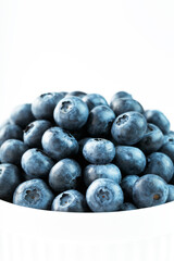 Blueberries are ripe berries in a white Cup on a white background.