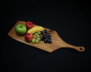 photo of wooden cutting board products and wooden trays, by adding properties to a variety of fresh fruit. Looks very attractive and elegant.