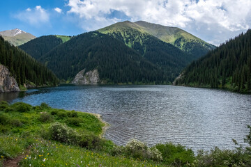 Beautiful view to Middle Kolsai or Mynzhylky lake with mountains background. Summer vacation concept. Scenic travel background. Travel in Kazakhstan concept.