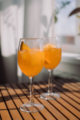 Glasses of traditional Italian aperitif on wooden table at terrace.