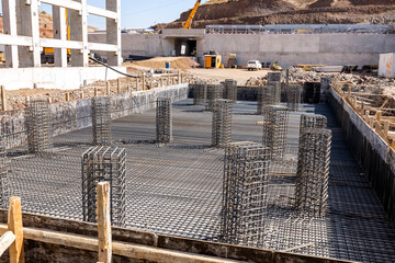 View of the rebar beam cages on the foundation for concrete and a new industrial plant. A tied...