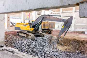 The excavator is digging in the building of the construction site.