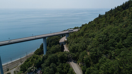 Aerial view of high bridge and mountain road with cars and truck, Black Sea, Russia