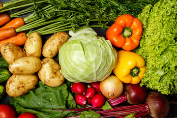 Top view of fresh assorted vegetables on dark black background