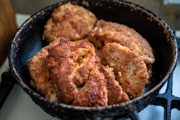 Sliced ​​chicken in breadcrumbs fried in a pan