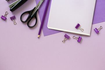 Layout of various purple school supplies on a lilac background