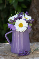 Sommer-Blumenstrauss mit Margeriten und Lavendel in lila Vase