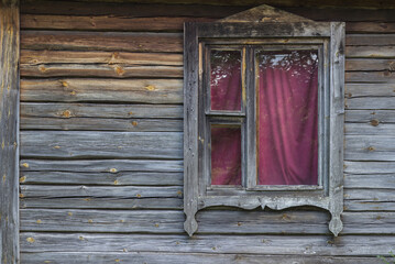 Naklejka na ściany i meble Old wall of a wooden village house with a window