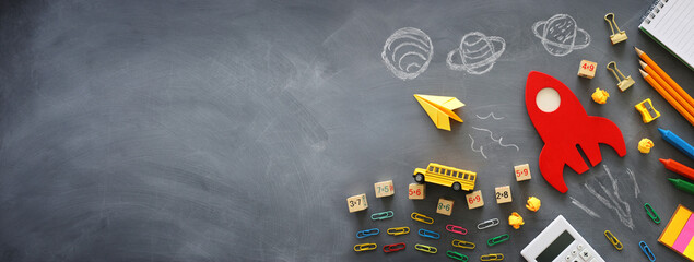 education. Back to school concept. wooden red rocket over blackboard background. top view, flat lay