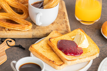 Spanish breakfast, churros with chocolate and crusty  french toast with butter and jam ,coffee and...