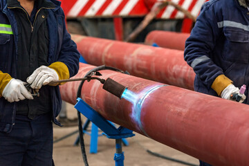 The welder is preheating to pipeline before welding. The phenomenon of heating the joint in the...