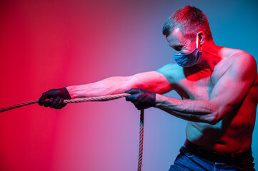 Image of a man in mask and gloves pulling a rope