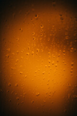 Raindrops on window glass,condensation on the window,natural background,color texture,orange abstract and pattern
