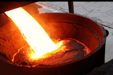 The hot slag of the copper is pouring to the large melting pot. - obrazy, fototapety, plakaty