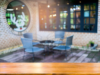 Blurred table and chairs on the terrace backgroundimage of blurred outdoor coffee hut on day time in garden for background usage .