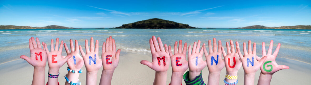 Children Hands Building Colorful German Word Meine Meinung Means My Opinion. Ocean And Beach As Background