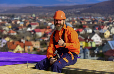 Builder enjoy success. Construction Industry and Waterproofing. roofer working on roof structure of...