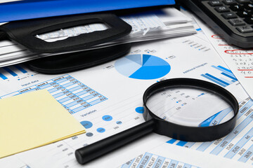 business office desk closeup - financial reports, analysis and accounting, set of documents, tables and graphs, various items for bookkeeping, calculator