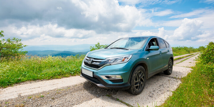 mnt. runa, ukraine - JUN 22, 2019: cyan honda cr-v suv on the mountain road. explore the wilderness concept. ridge in the distance. sunny weather. clouds on the blue sky