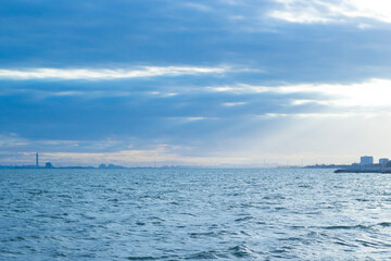 Obraz premium The sky is bright, cloudy and there are boats sailing in the sea.