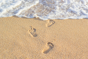 footprints of people stepping on the sand in the sea