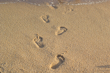 Fototapeta na wymiar footprints of people stepping on the sand in the sea