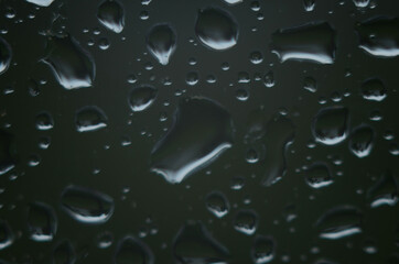 Rain drops on window glasses surface with cloudy background . Natural Pattern of raindrops on...