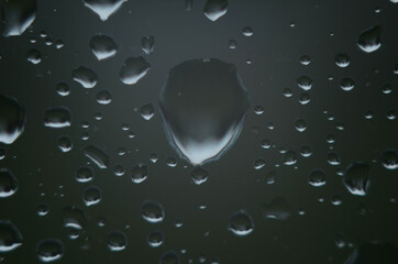Rain drops on window glasses surface with cloudy background . Natural Pattern of raindrops on...
