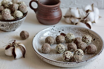 Fototapeta na wymiar Homemade nut candies on a white plate.Energy balls are prepared from dried fruits, granules, honey, sesame, cocoa, nuts.Healthy vegetarian treat. No baking. Healthy food, easy to make. Recipe.