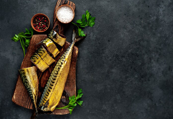 
Smoked mackerel on a cutting board on a stone background 
with copy space for your text
