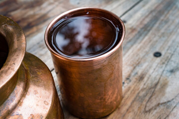 A copper water holder and a glass. In Indian ayurvedic culture it has been established that...