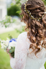 Curly bride with beautiful hairstyle holds wedding bouquet
