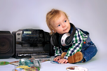 Fototapeta na wymiar Little baby, european, blond hair. The boy plays a DJ. The concept of leisure and entertainment.