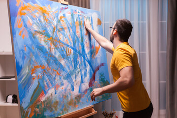 Hand painting technique on large canvas in art studio. Modern artwork paint on canvas, creative,...