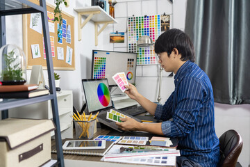 Asian men Architect or graphic designer designing a layout selection swatch samples for coloring screen