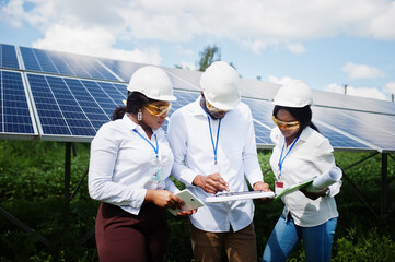 African american technician checks the maintenance of the solar panels. Group of three black...