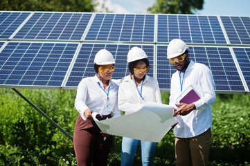 African american technician checks the maintenance of the solar panels. Group of three black...