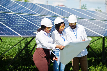 African american technician checks the maintenance of the solar panels. Group of three black...