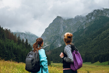 Rear view shot of two women friends enjoying beautiful view of Rysy peaks in Tatra mountains. Poland, Slovakia