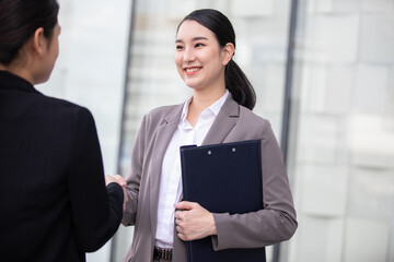 Beautiful asian business woman shaking hands in modern city work office.