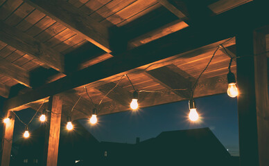 The garland of  light bulbs hanging on the wooden terrace
