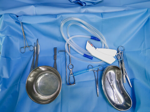 Various surgical instruments lie on an operating table.