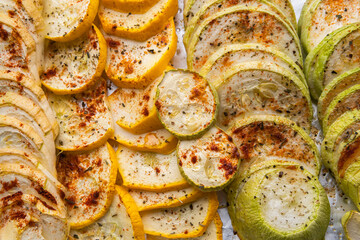 A lot of round pieces (slices) of prepared (cooked) in oven spicy, piquant and heady vegetable marrows (squash, zucchini, courgette)