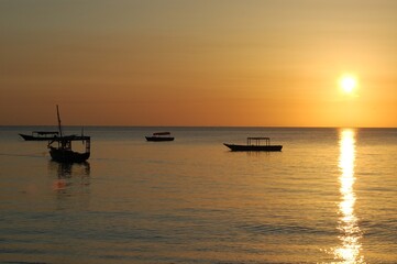 Fototapeta na wymiar Boats on the sunset horizon of Zanzibar, Tanzania 