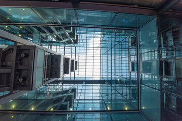 Modern glass elevator and pedestrian stairway entrances.